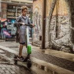 boy standing on black and white kick scooter