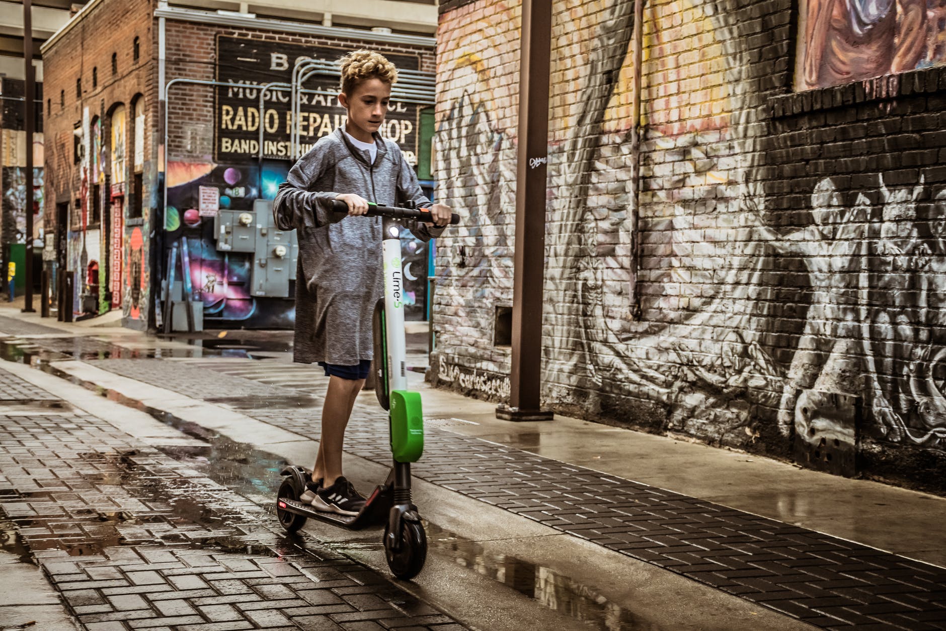 boy standing on black and white kick scooter